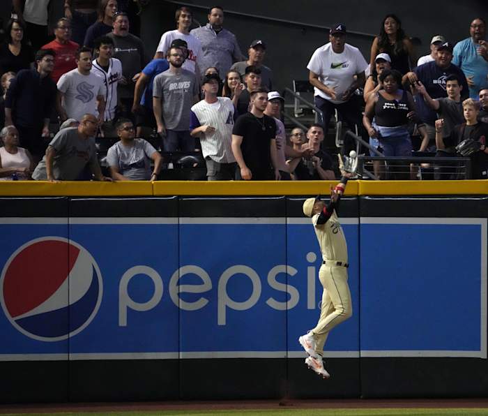 Jun 2, 2023; Phoenix, Arizona, USA; Arizona Diamondbacks left fielder Lourdes Gurriel Jr. (12) leaps at the wall and makes a catch against the Atlanta Braves during the ninth inning at Chase Field.